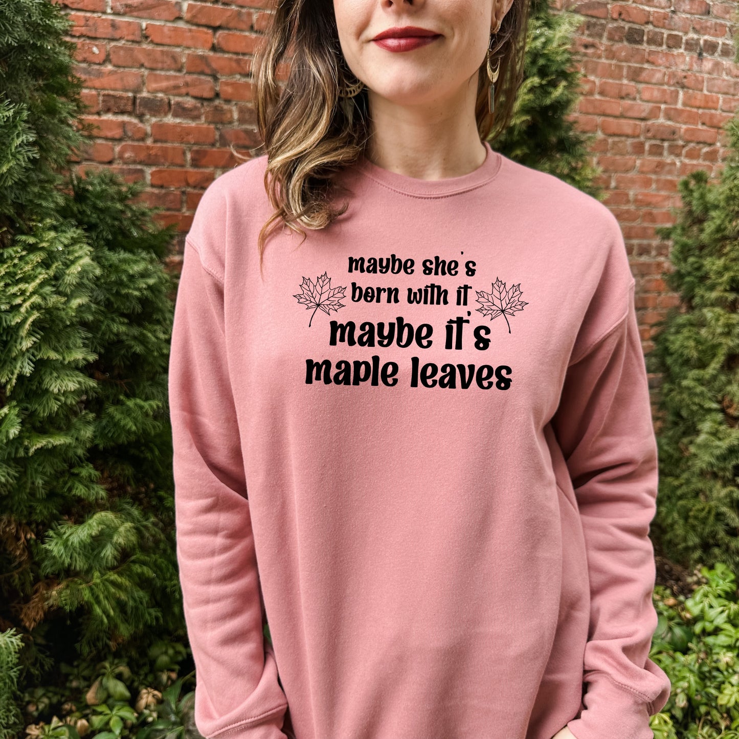 a woman wearing a pink sweatshirt that says maybe she's born with it maybe