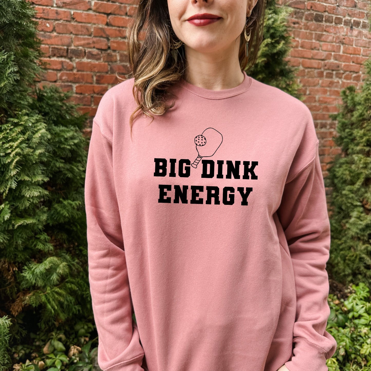 a woman wearing a pink sweatshirt that says,'big drink energy '