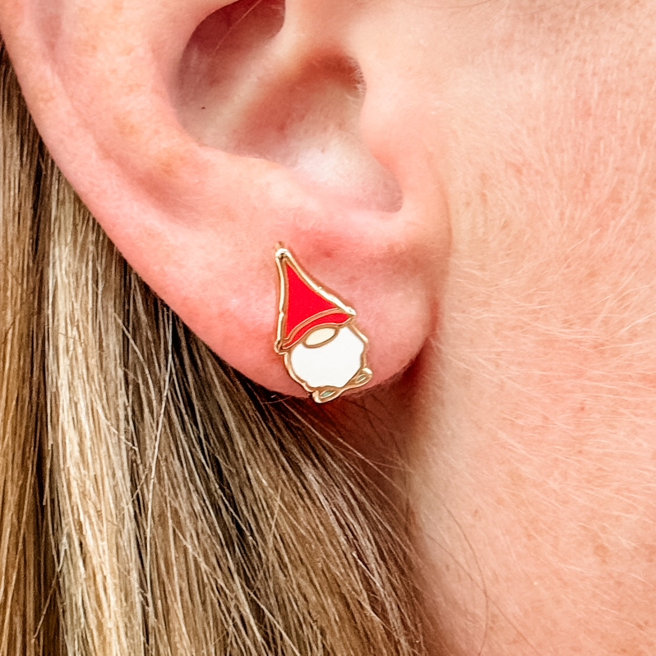 a close up of a person wearing a red and white earring