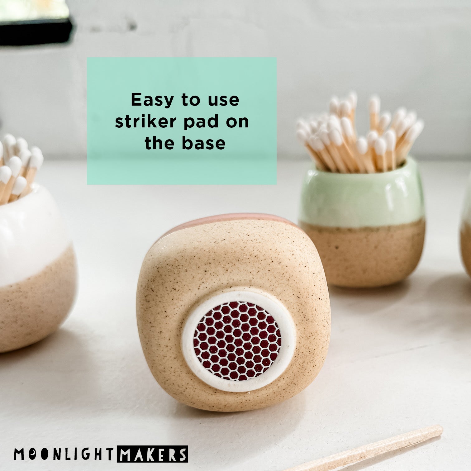 a couple of small ceramic containers with toothbrushes in them