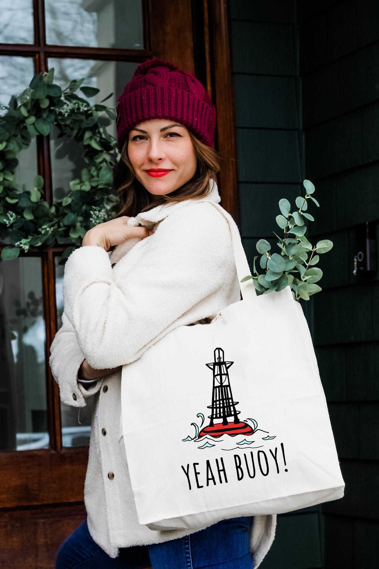 a woman carrying a bag that says yeah buoy