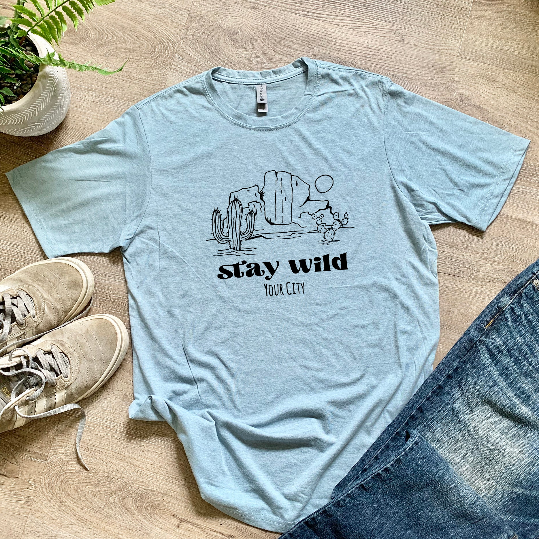 a t - shirt that says stay wild next to a pair of jeans