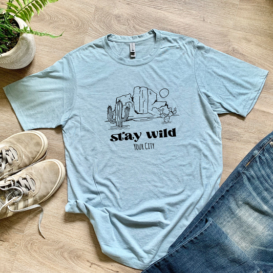 a t - shirt that says stay wild next to a pair of jeans