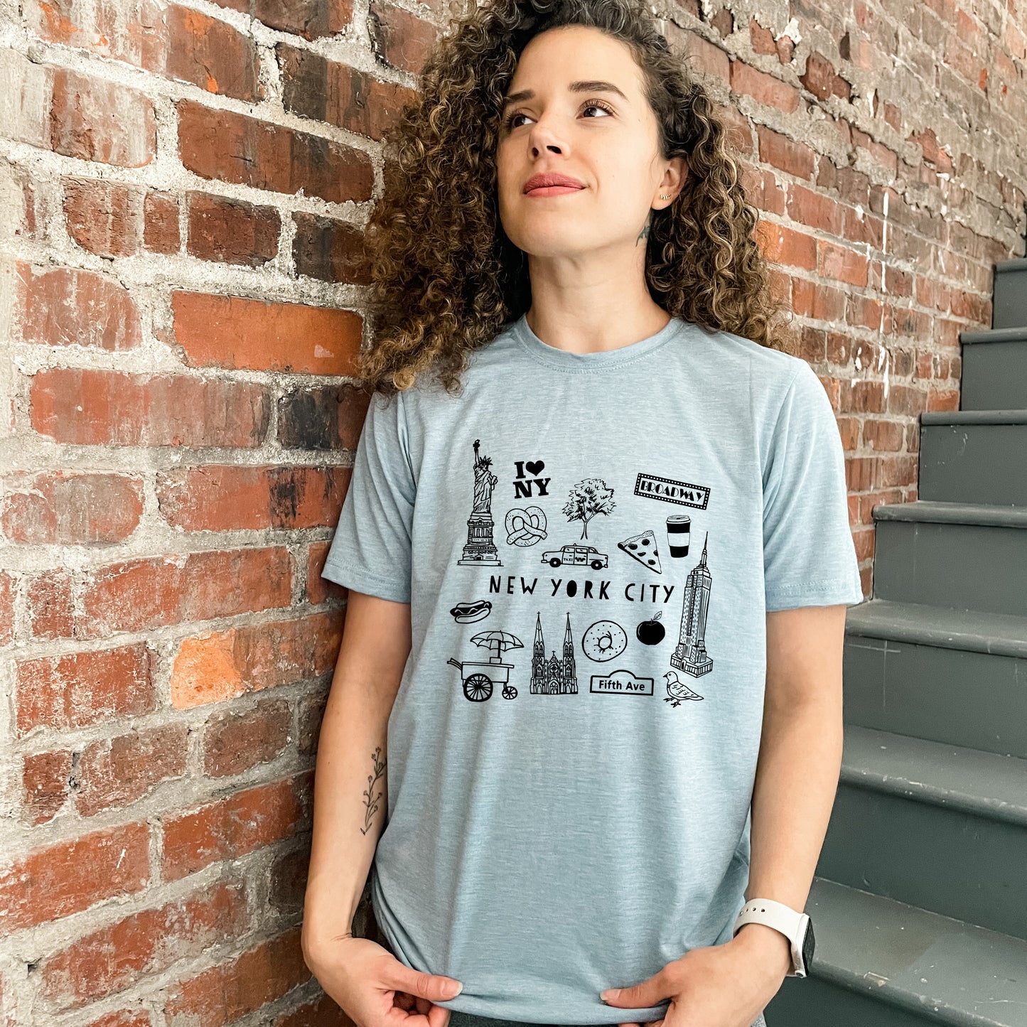 a woman standing in front of a brick wall