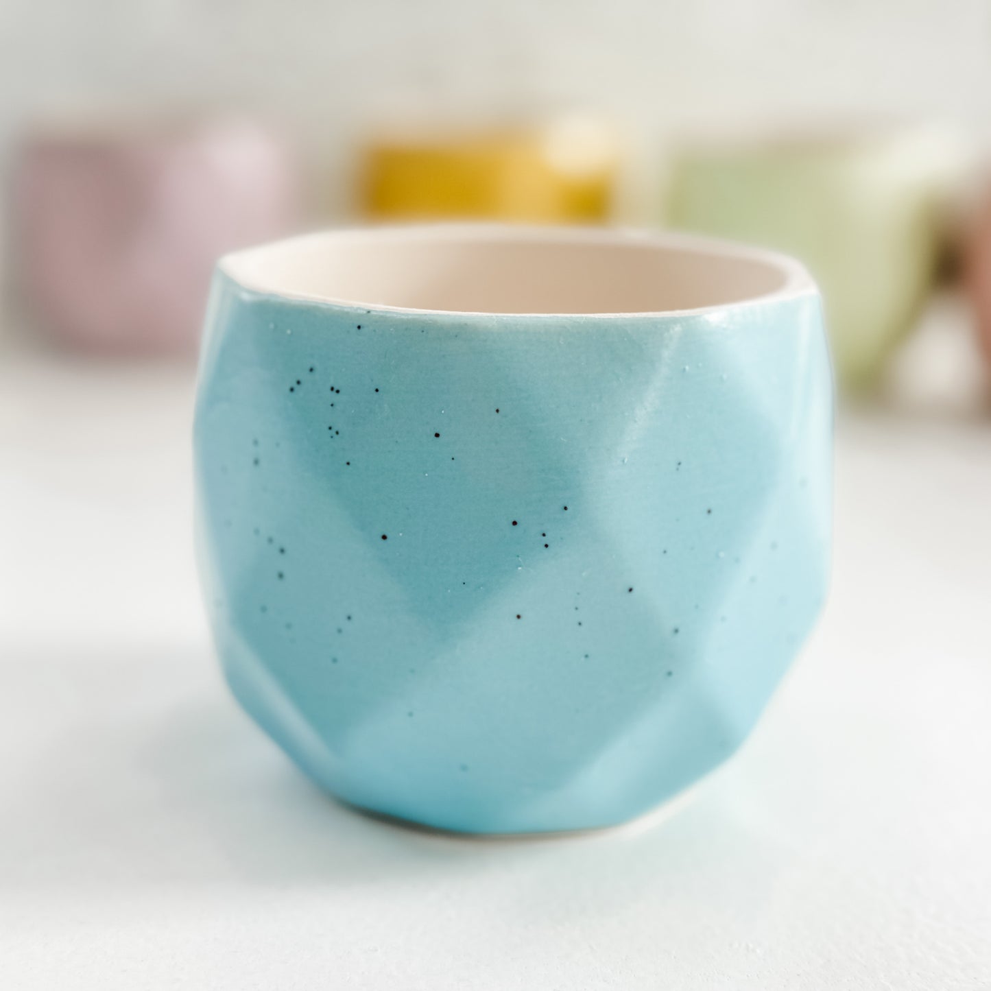 a blue cup sitting on top of a white table