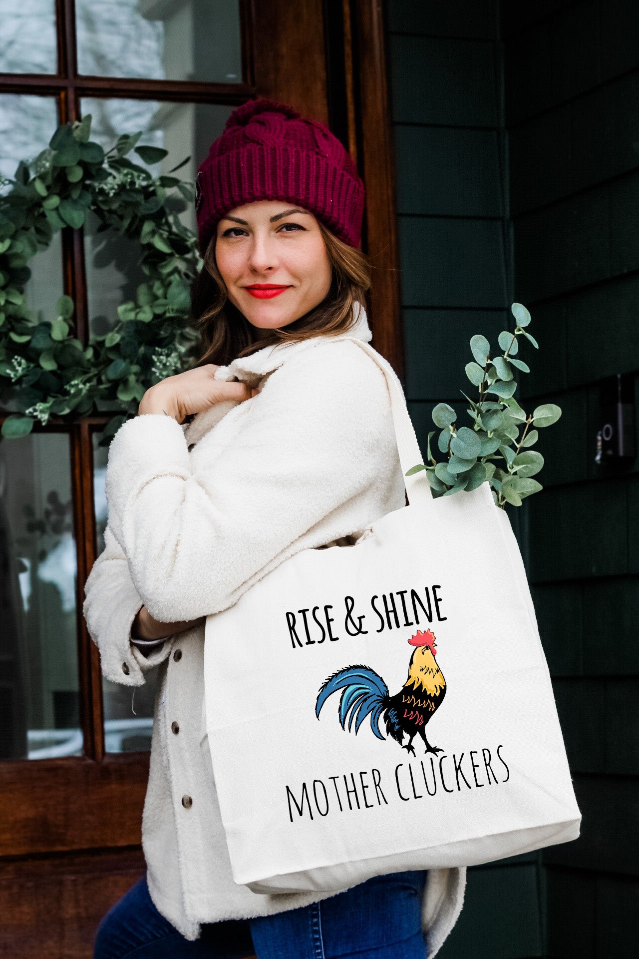 a woman carrying a tote bag with a rooster on it