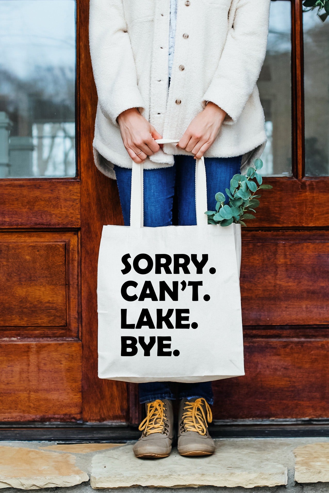 a woman holding a bag that says sorry can't lake bye