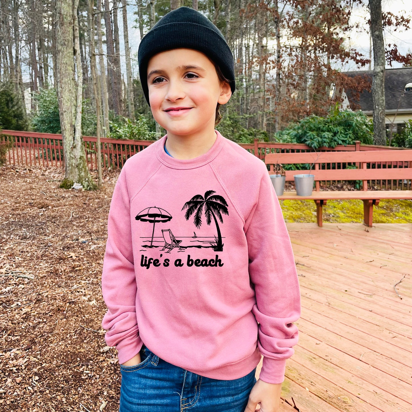 a young boy wearing a pink life's a beach sweatshirt