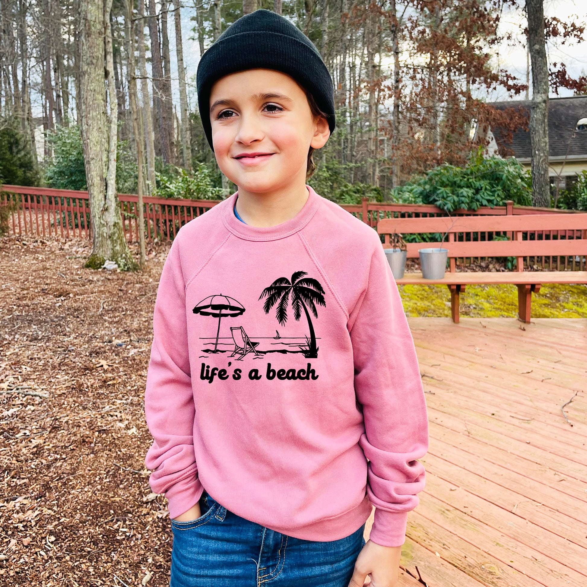 a young boy wearing a pink life's a beach sweatshirt