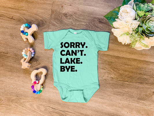 a baby bodysuit that says sorry, can't lake bye next to some