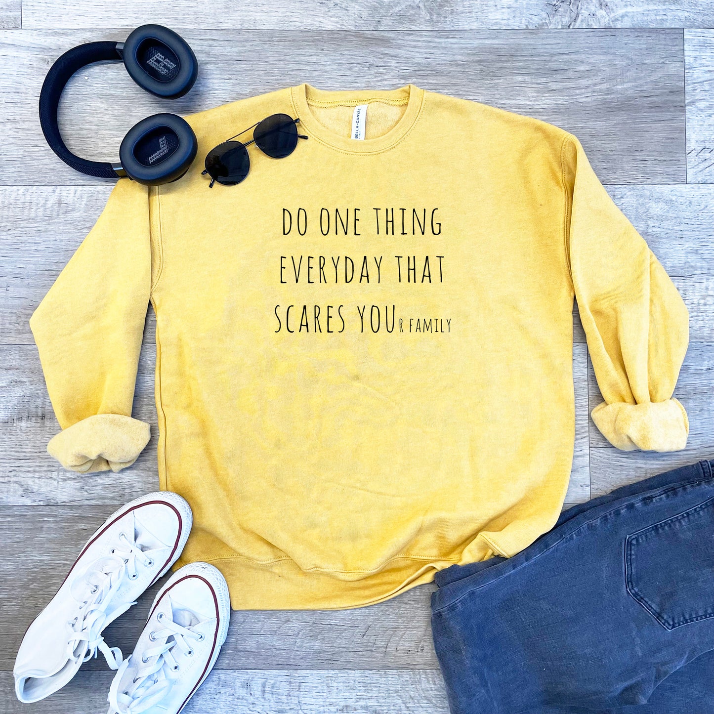 a yellow sweatshirt with a pair of black headphones and a pair of black sunglasses