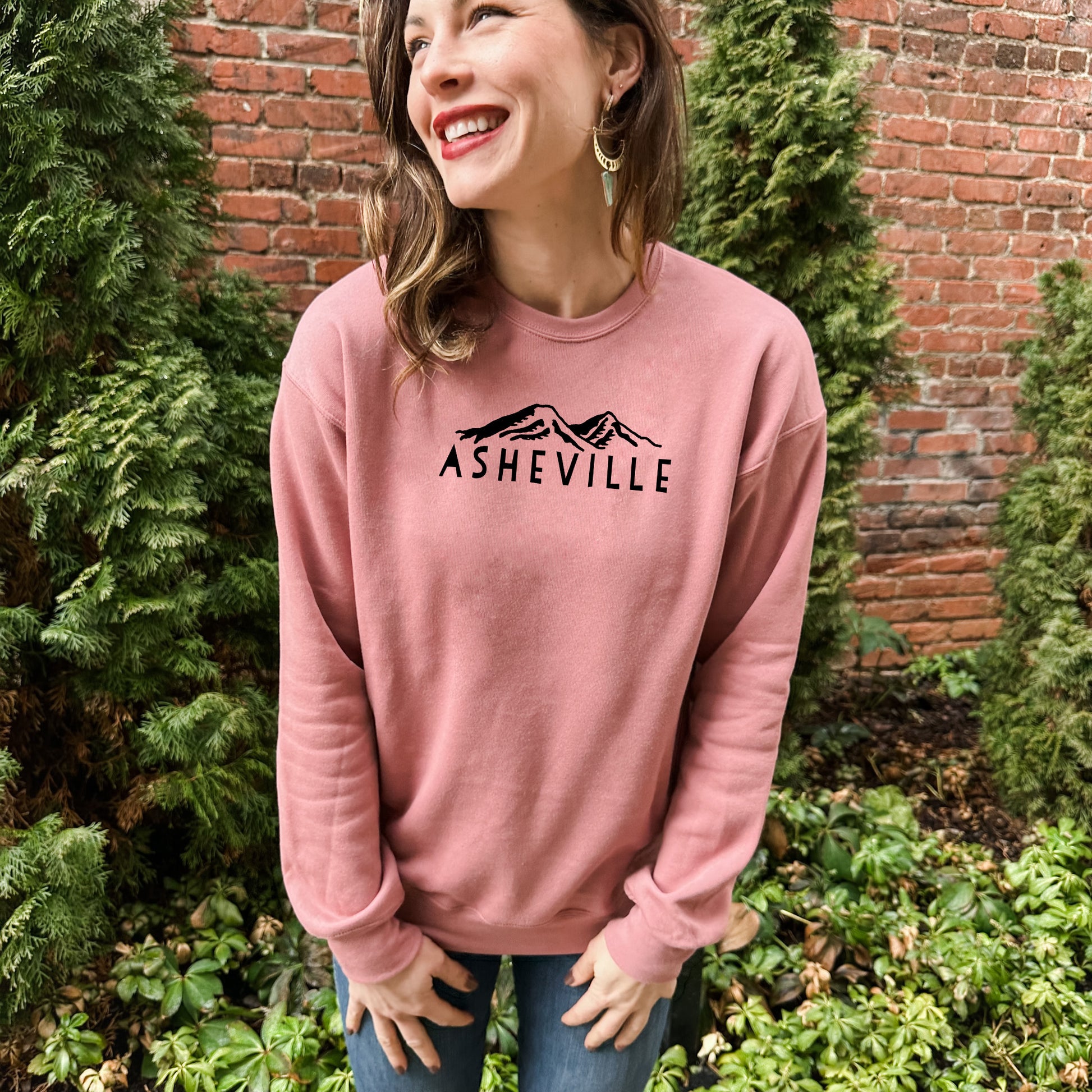 a woman standing in front of a brick wall