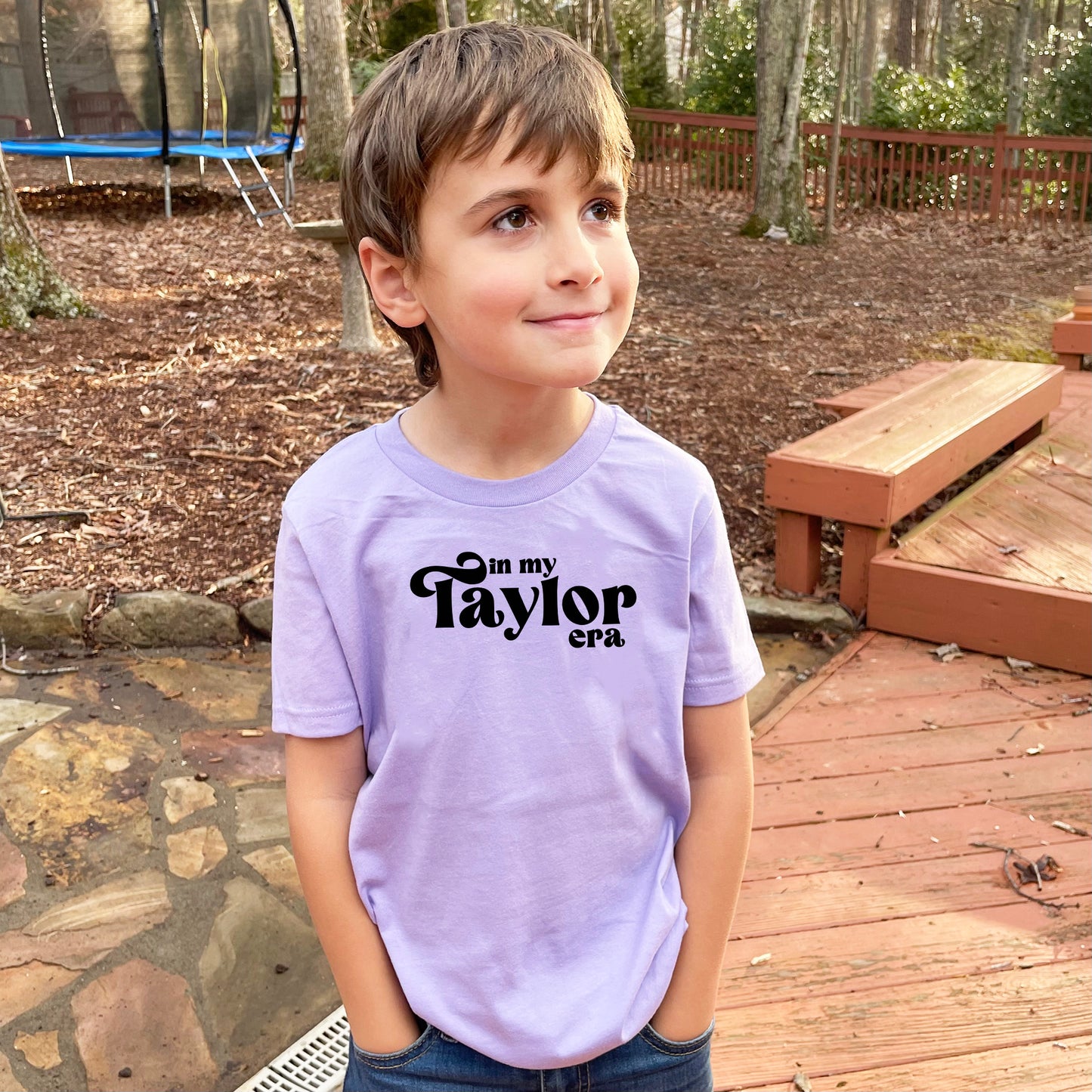 a young boy standing on a wooden deck