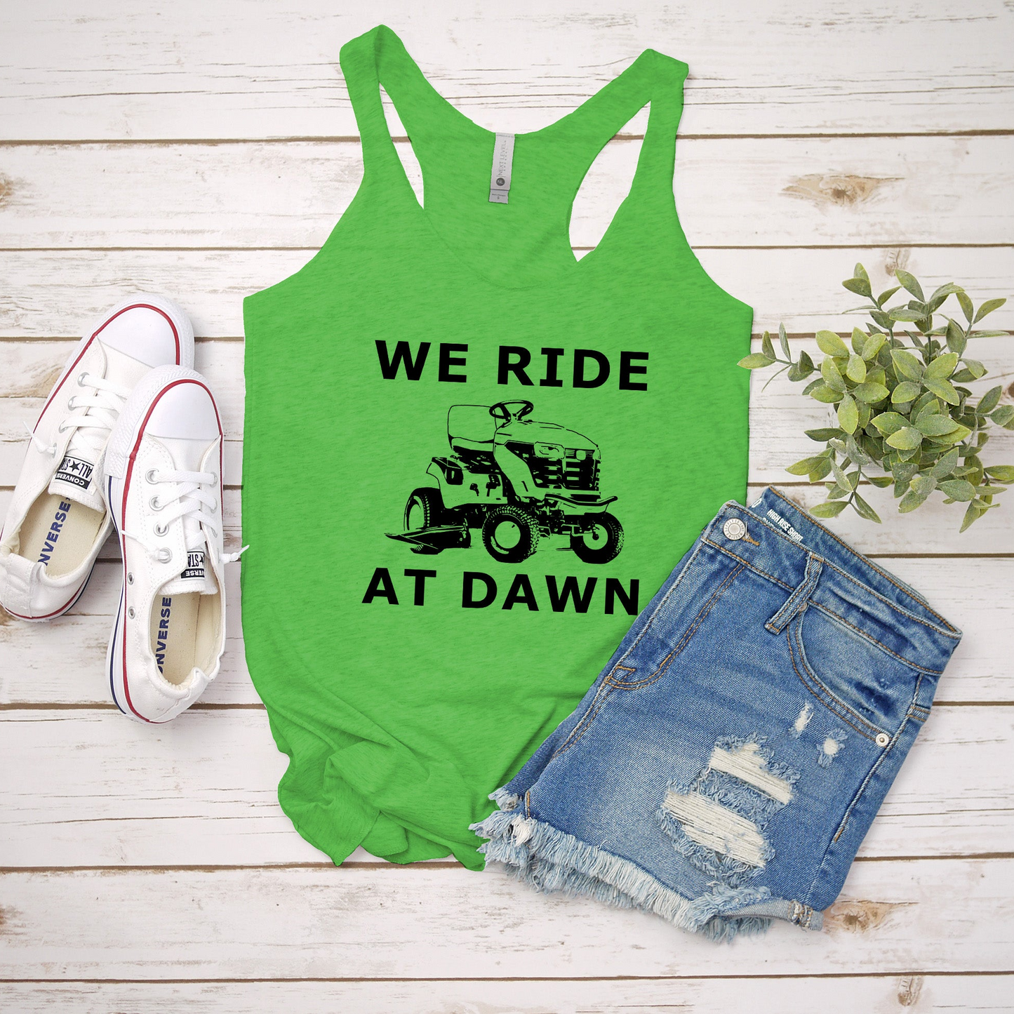 a green tank top that says we ride at dawn