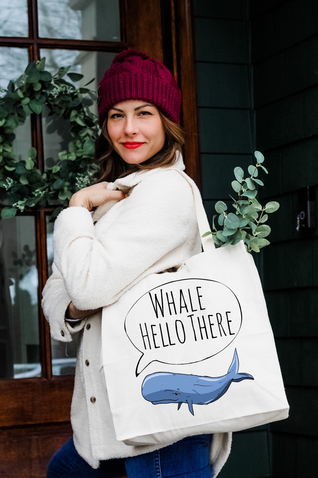 a woman carrying a whale hello there shopping bag