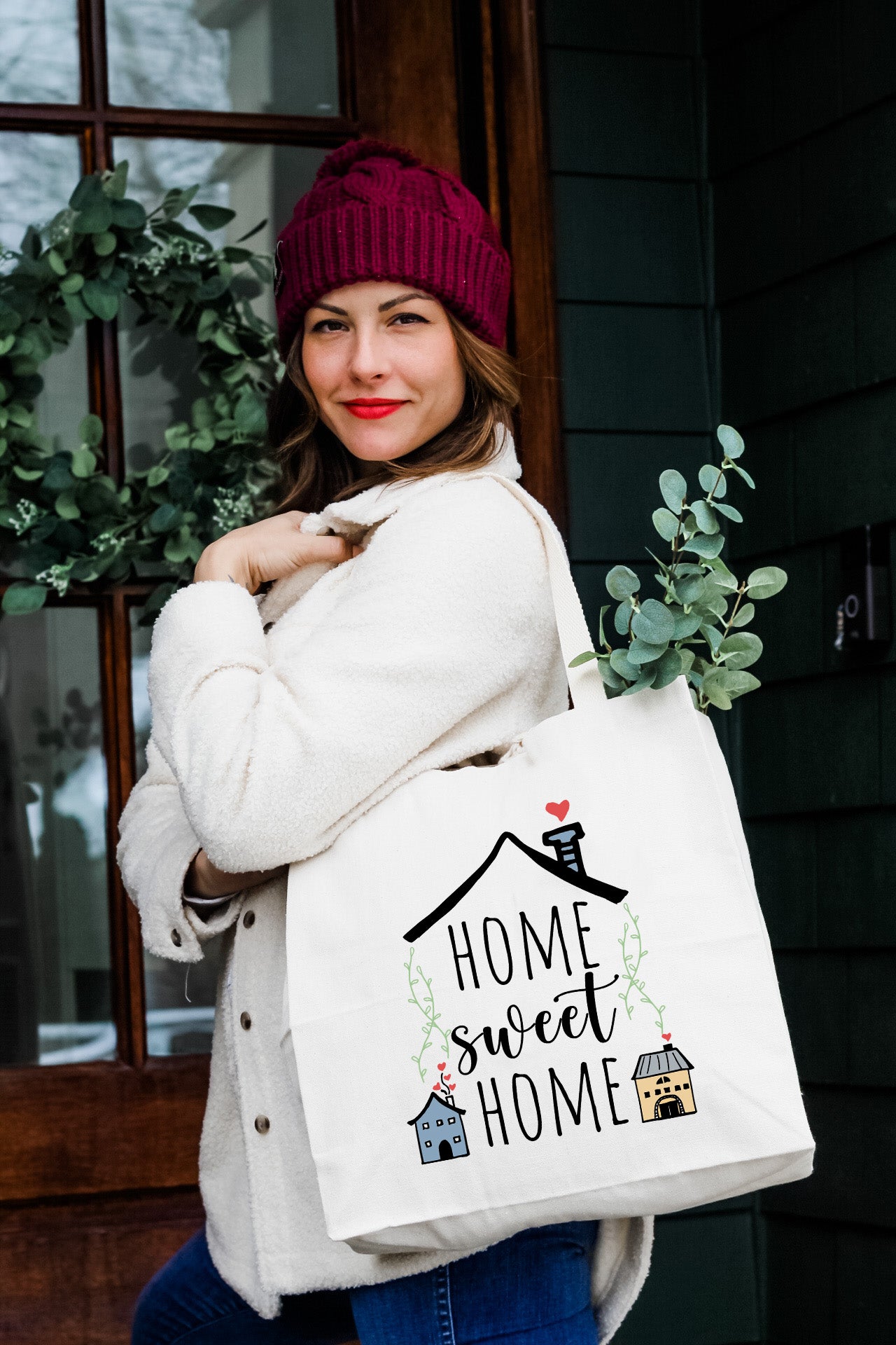 a woman carrying a bag that says home sweet home