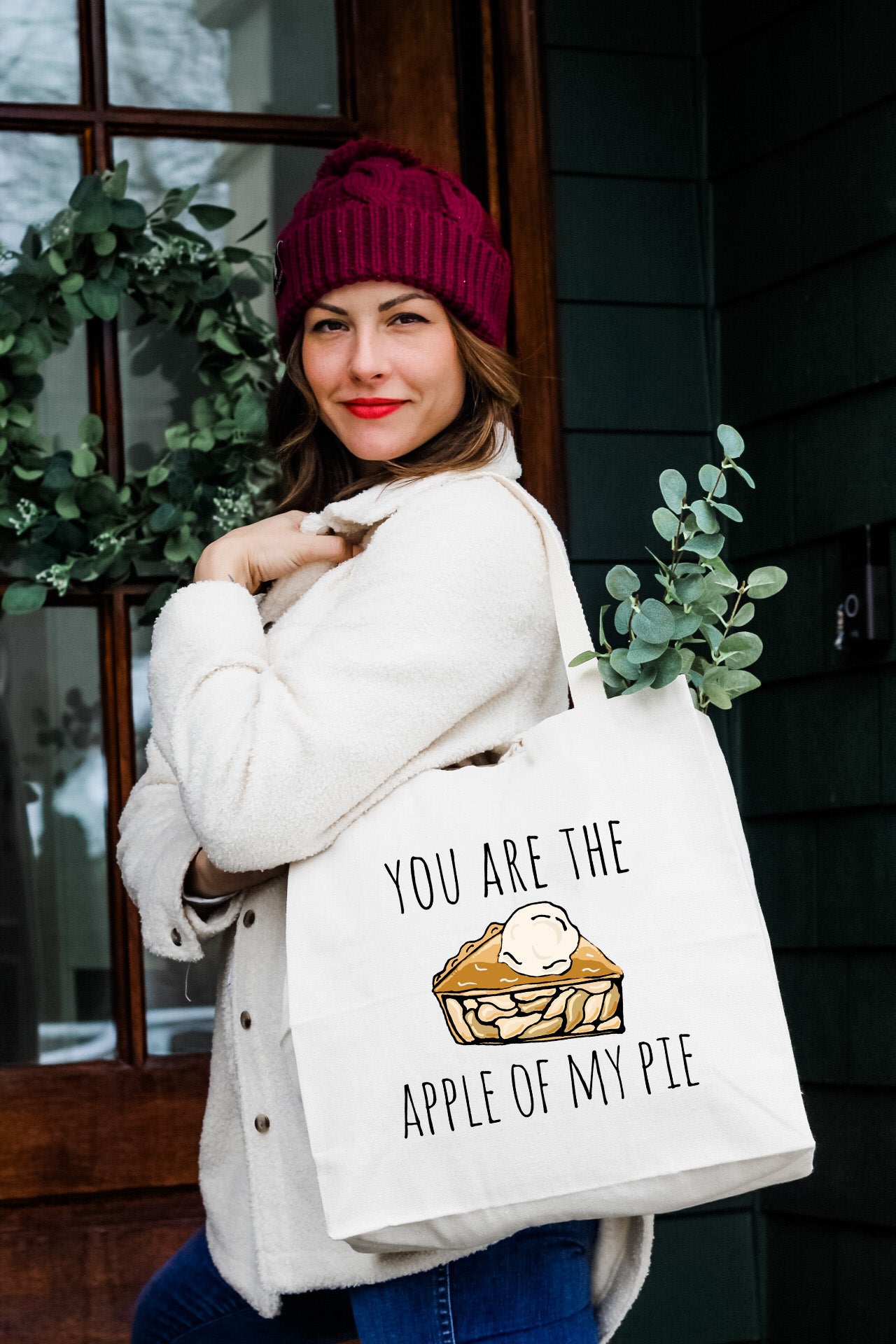 a woman carrying a bag that says you are the apple of my pie