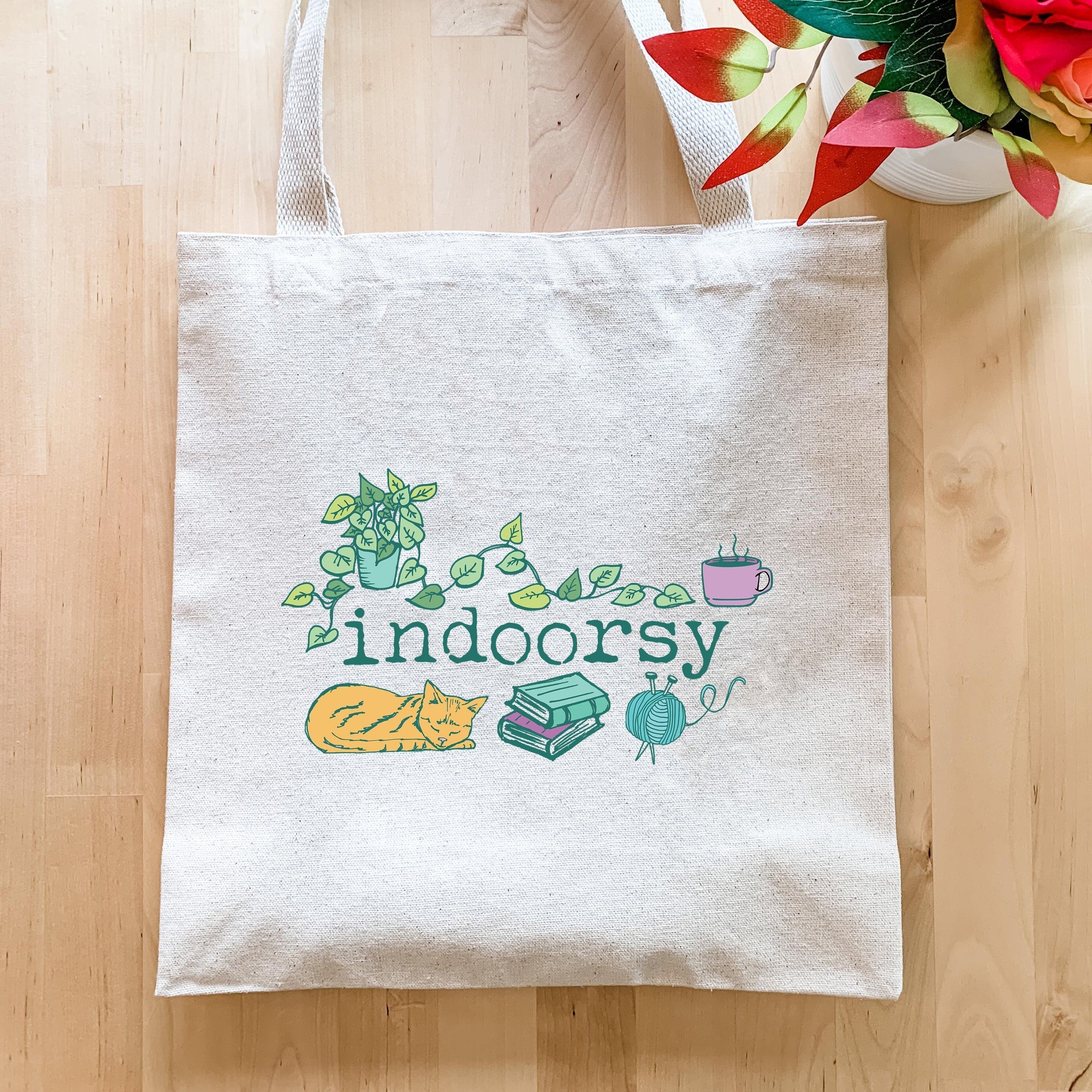 a white tote bag sitting on top of a wooden floor