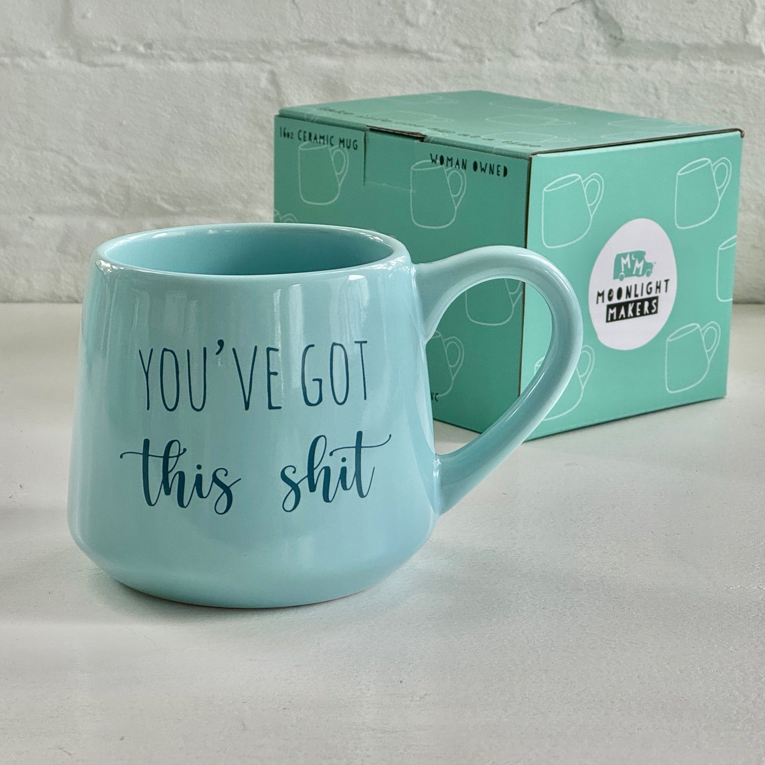 a blue coffee mug sitting next to a box of coffee