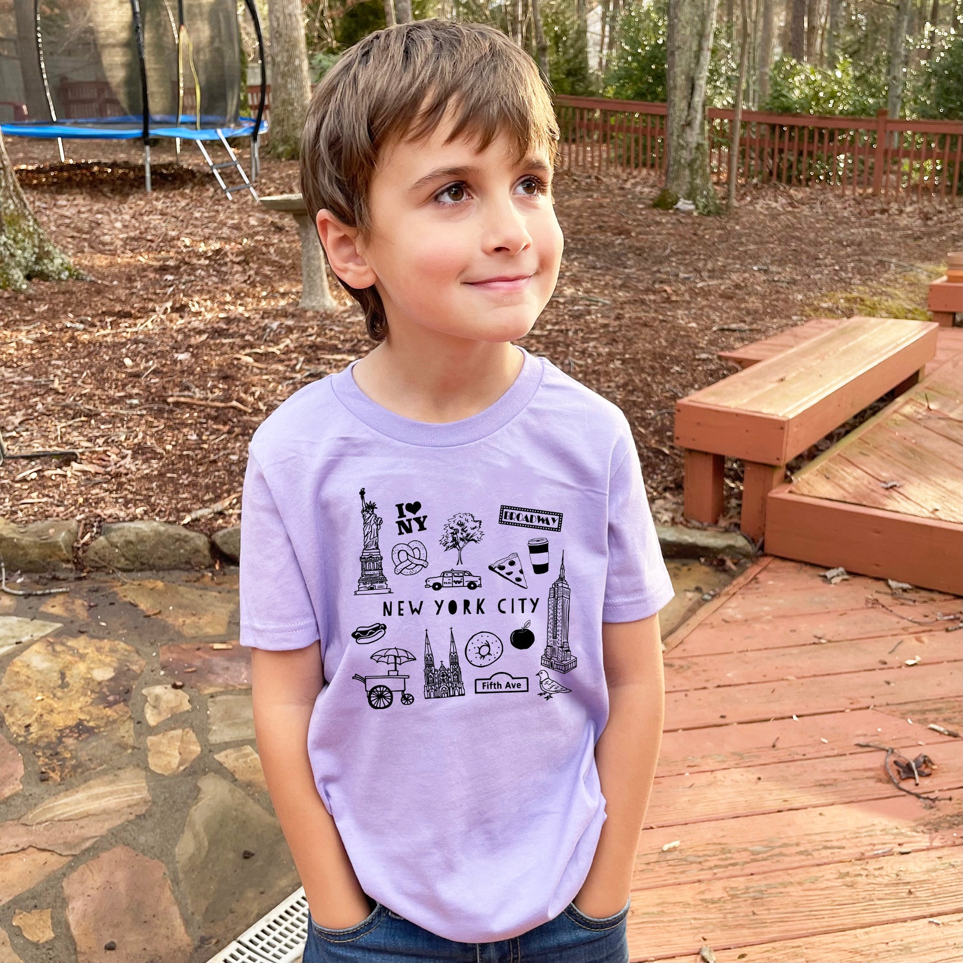 a young boy standing on a wooden deck