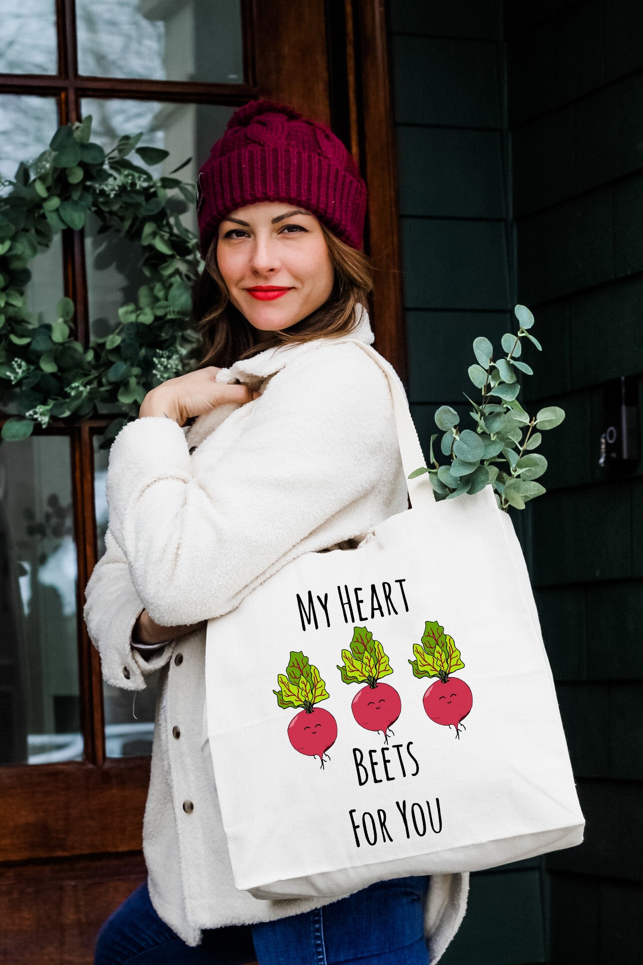 a woman holding a bag with beets for you on it