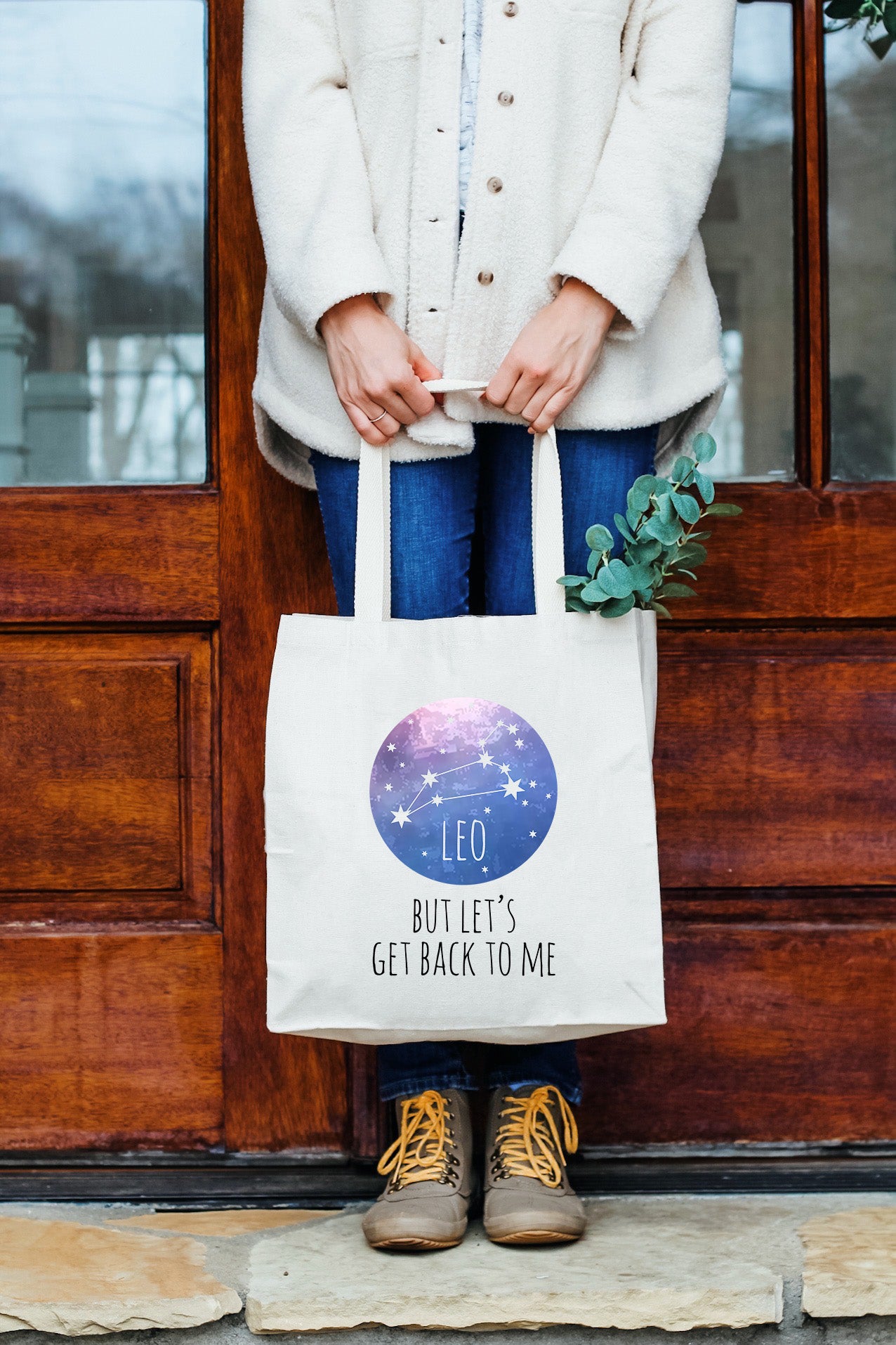 a woman holding a white bag with the words leo written on it