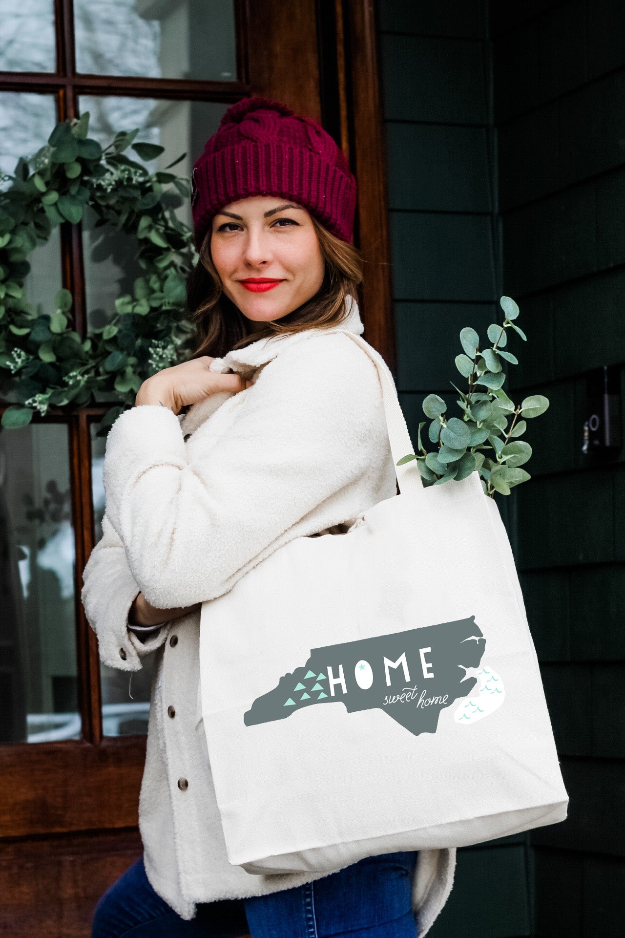 a woman carrying a white bag that says home