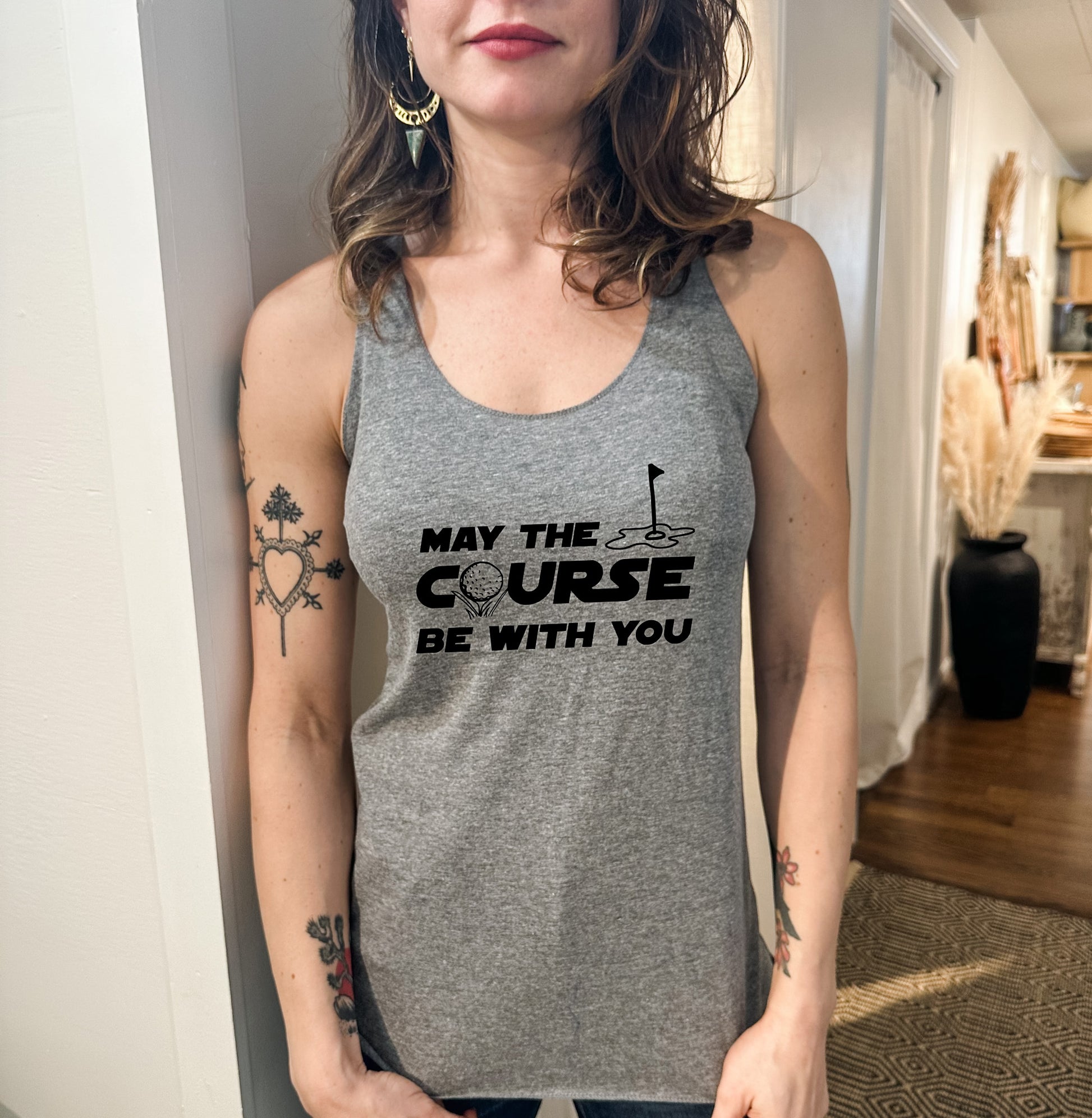 a woman wearing a gray tank top with a black lettering on it