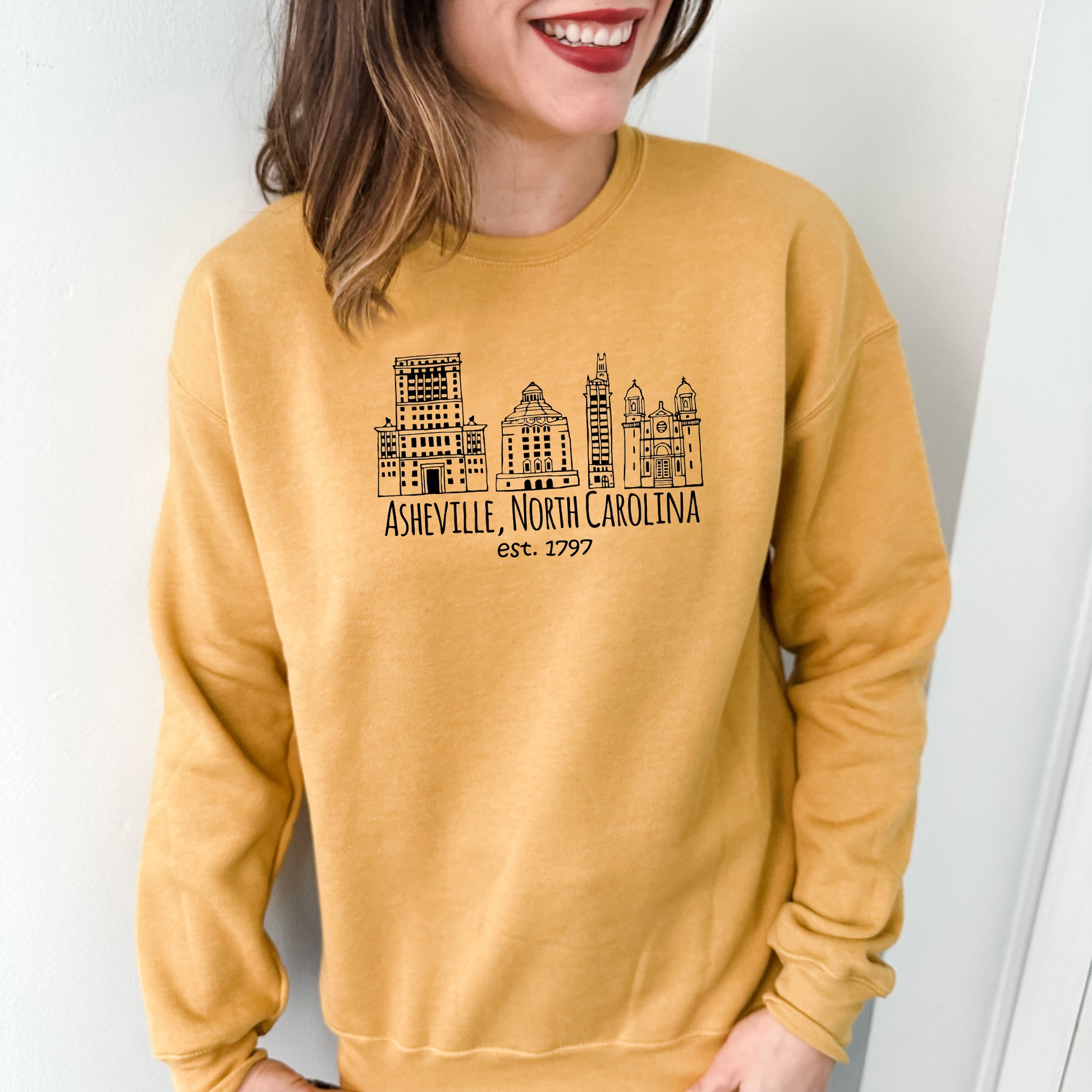 a woman wearing a yellow sweatshirt with a city skyline on it