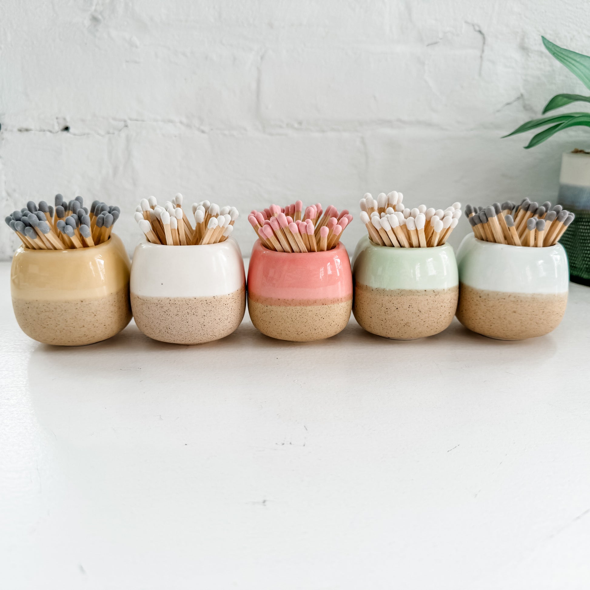 a row of ceramic toothbrush holders sitting on top of a table