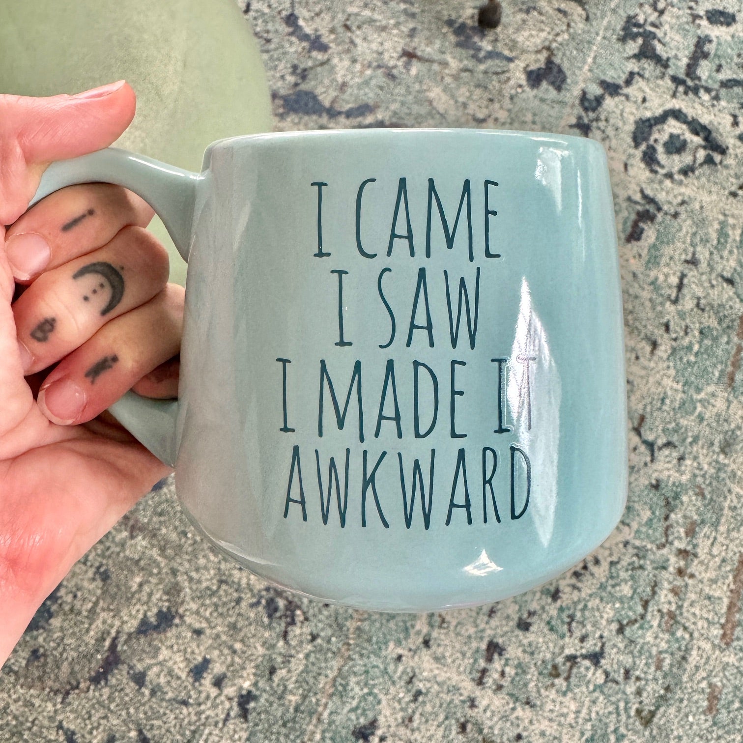 a person holding a coffee mug with writing on it