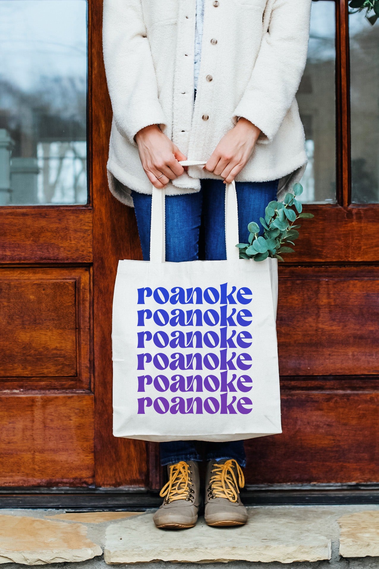 a woman standing in front of a door holding a bag