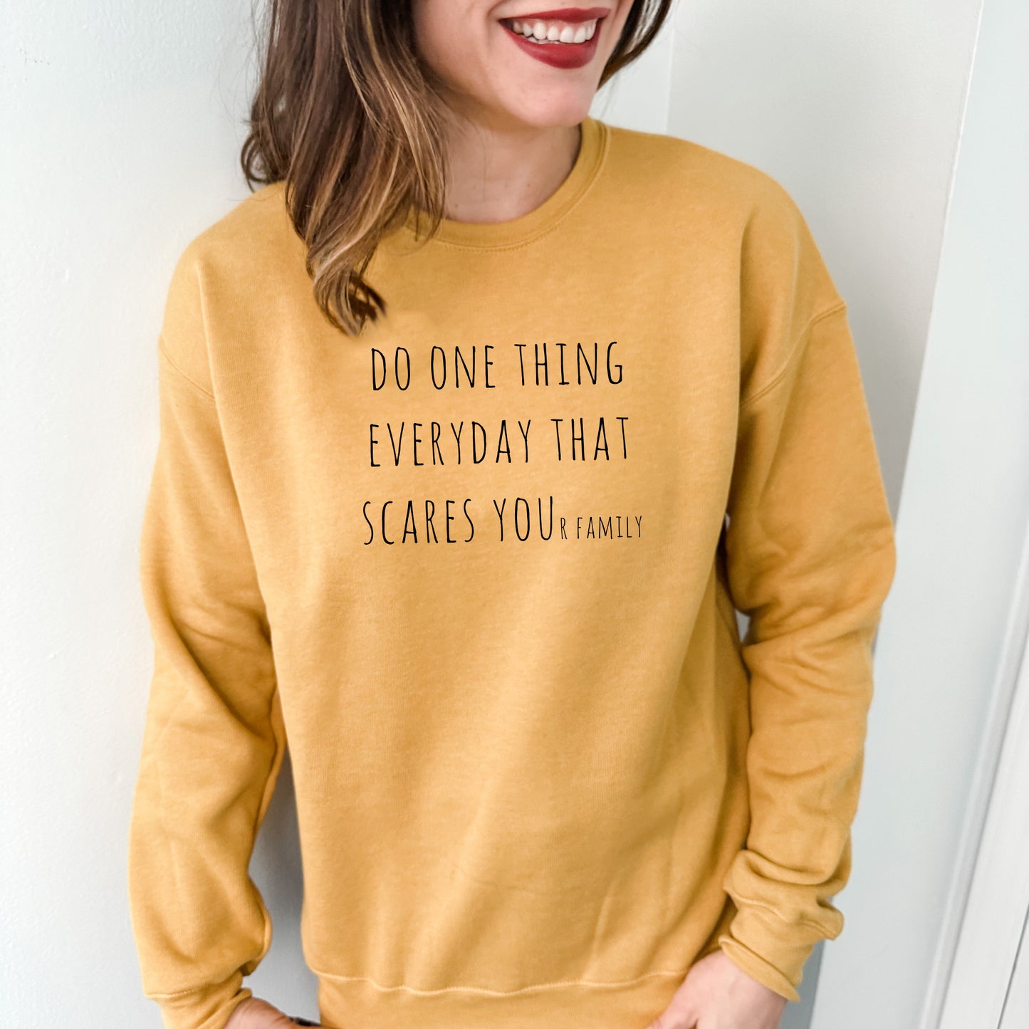 a woman wearing a sweatshirt that says do one thing everyday that scares you family