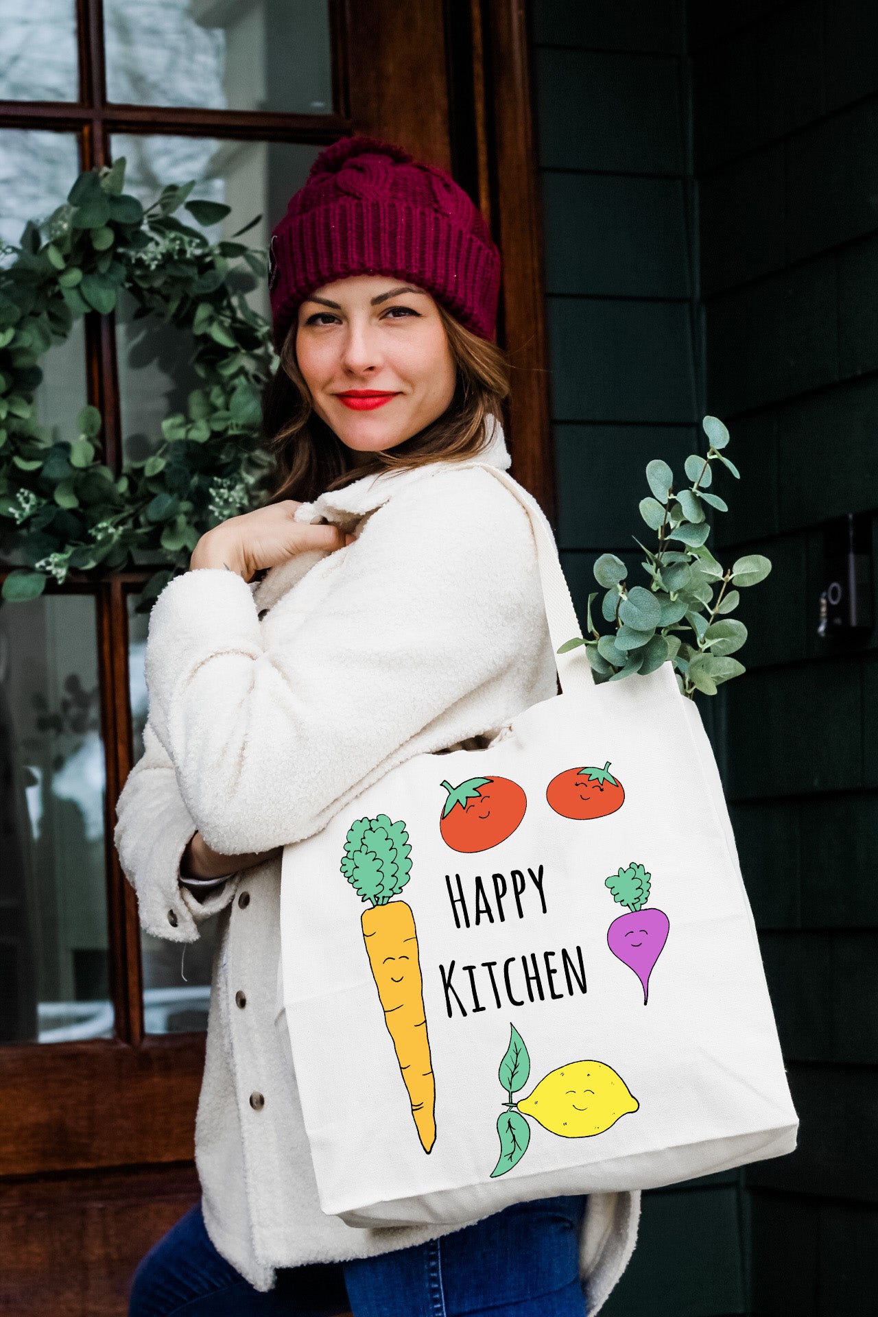 a woman holding a bag that says happy kitchen