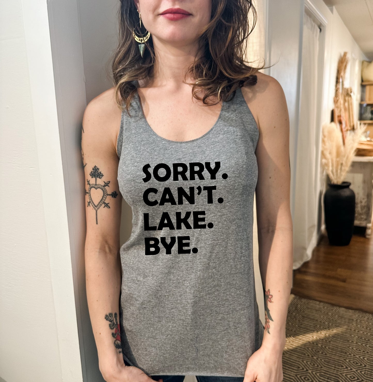 a woman wearing a tank top that says sorry can't lake bye