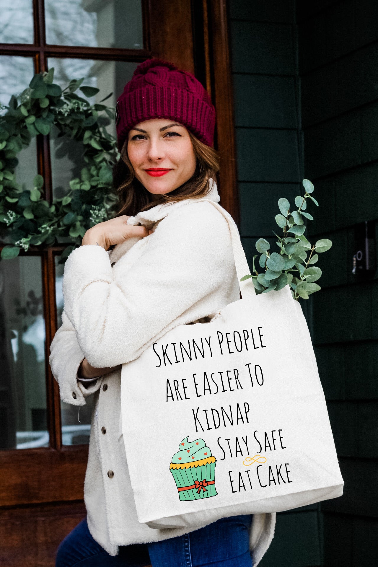 a woman holding a bag that says skinny people are easier to keep keep stay safe