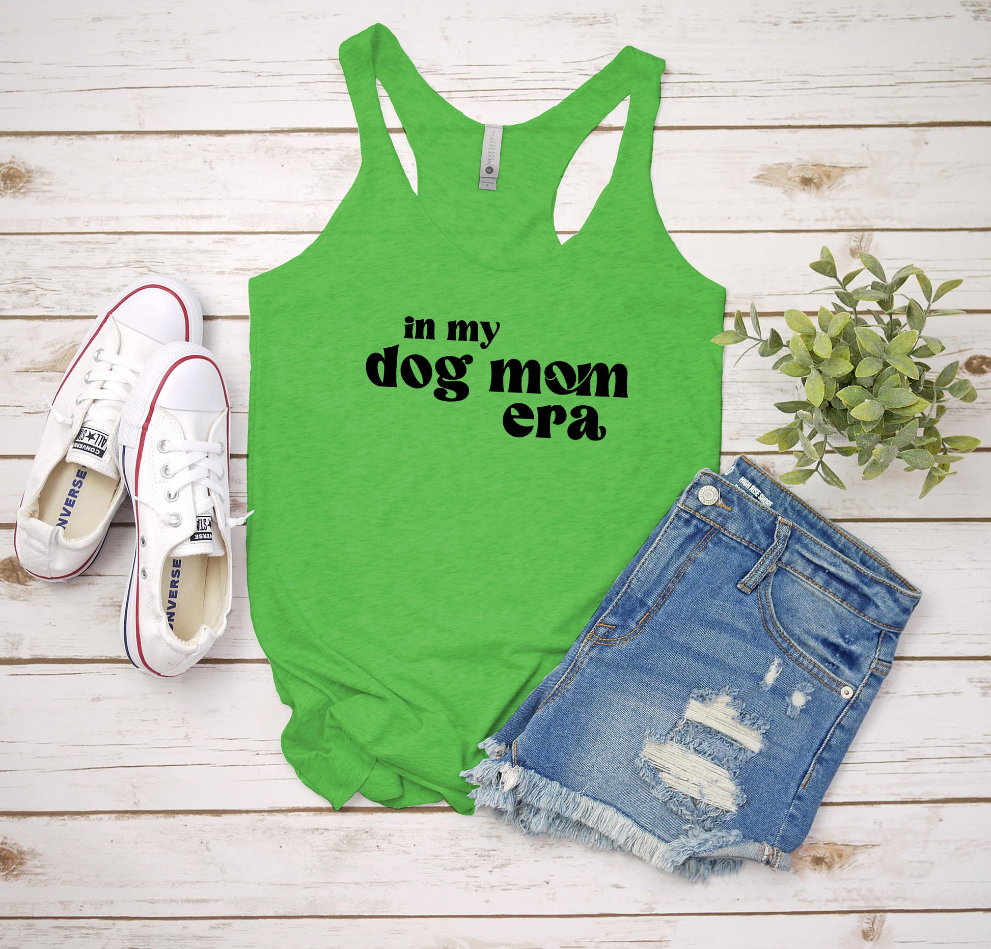 a green tank top that says in my dog mom era