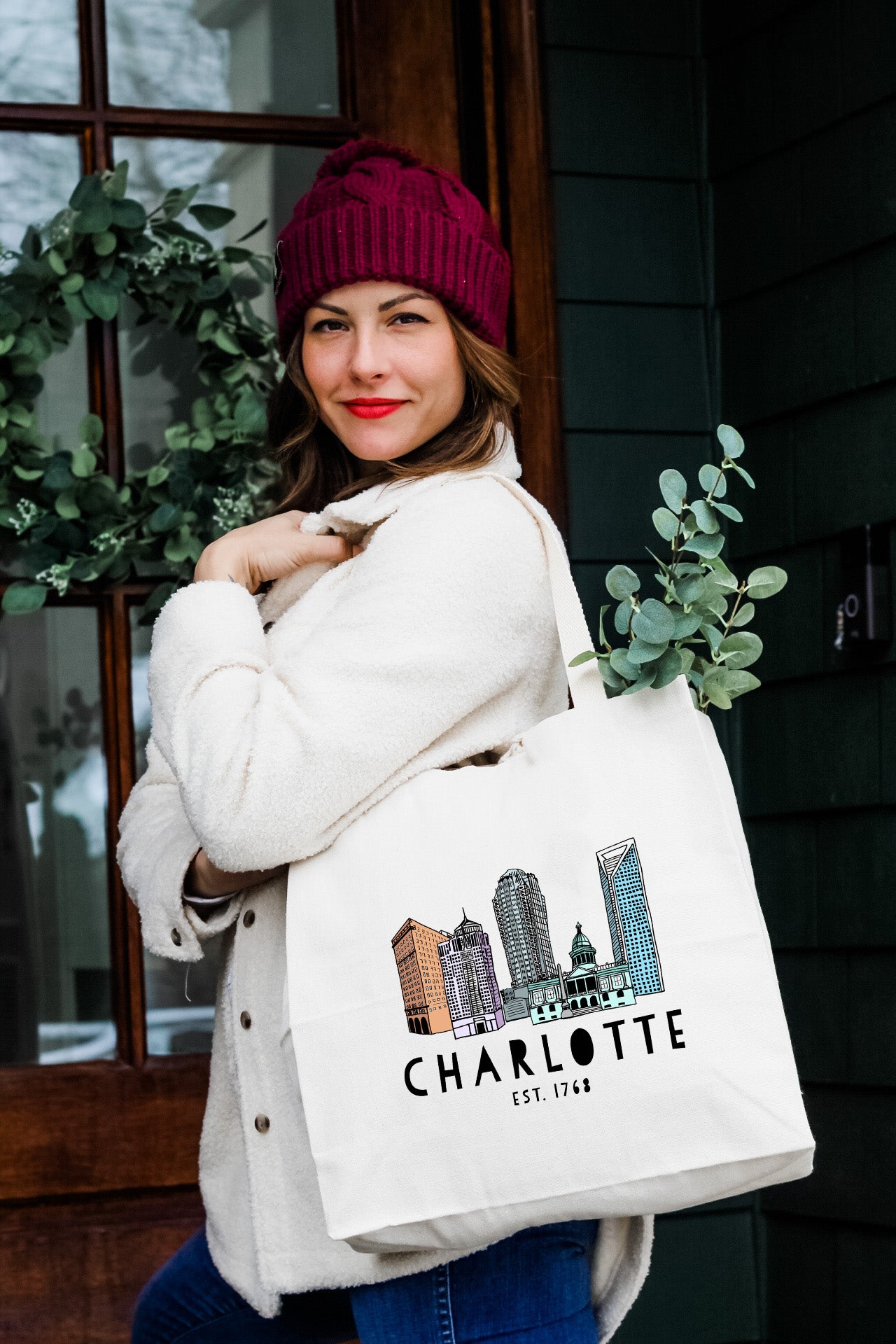 a woman carrying a white bag with a city skyline on it
