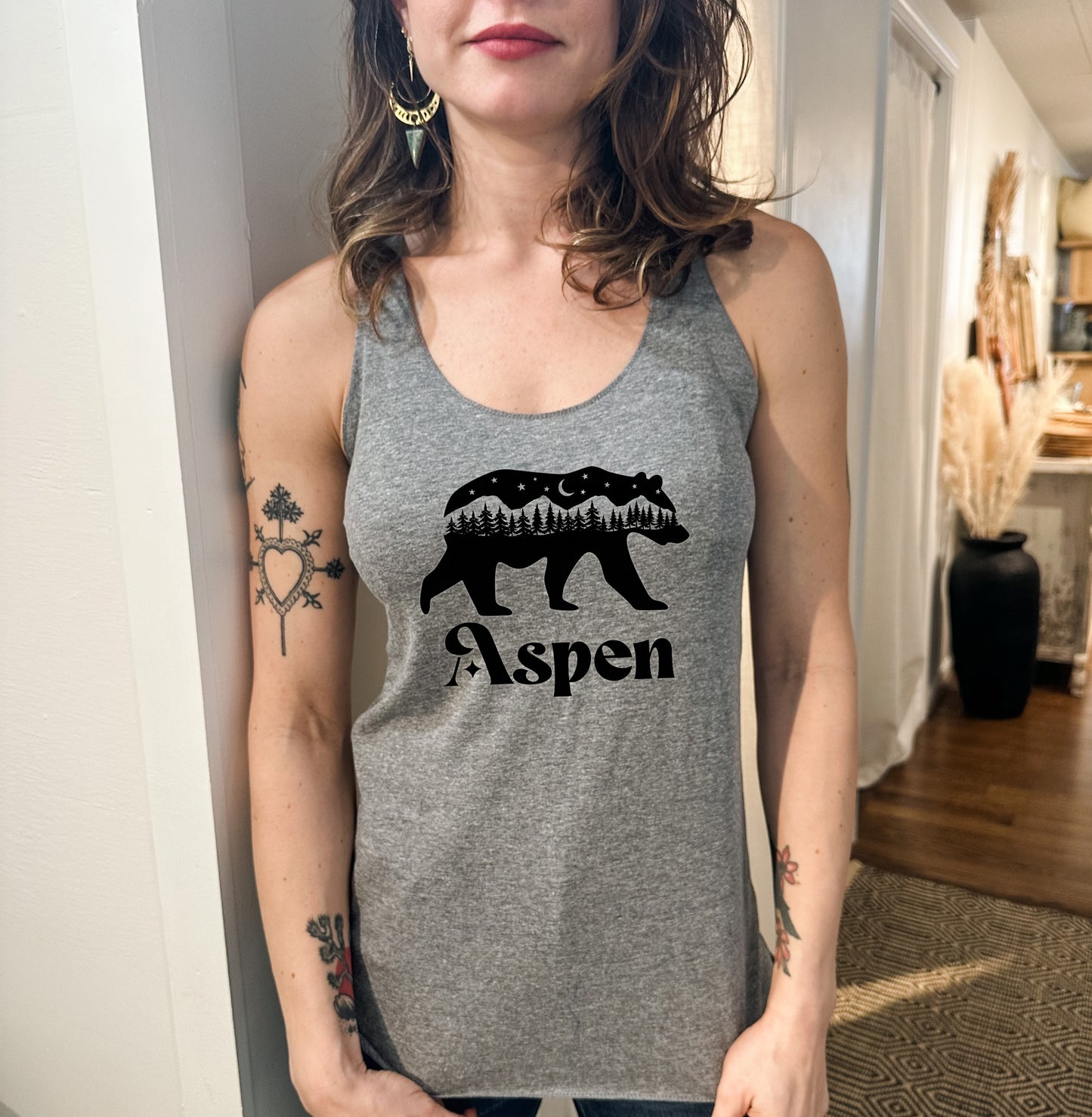 a woman wearing a tank top with a bear on it