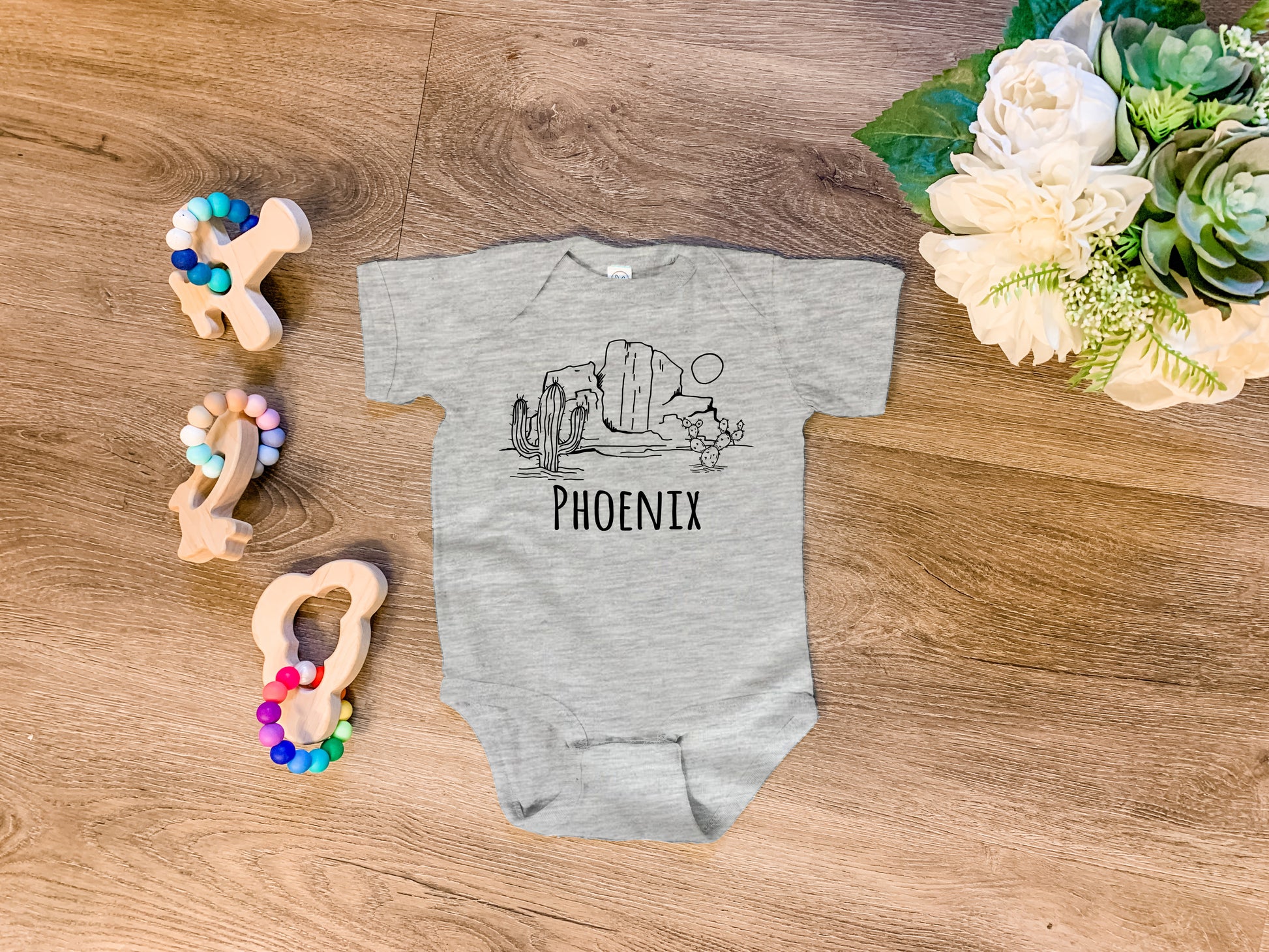 a baby's bodysuit with the word pieonix on it next to