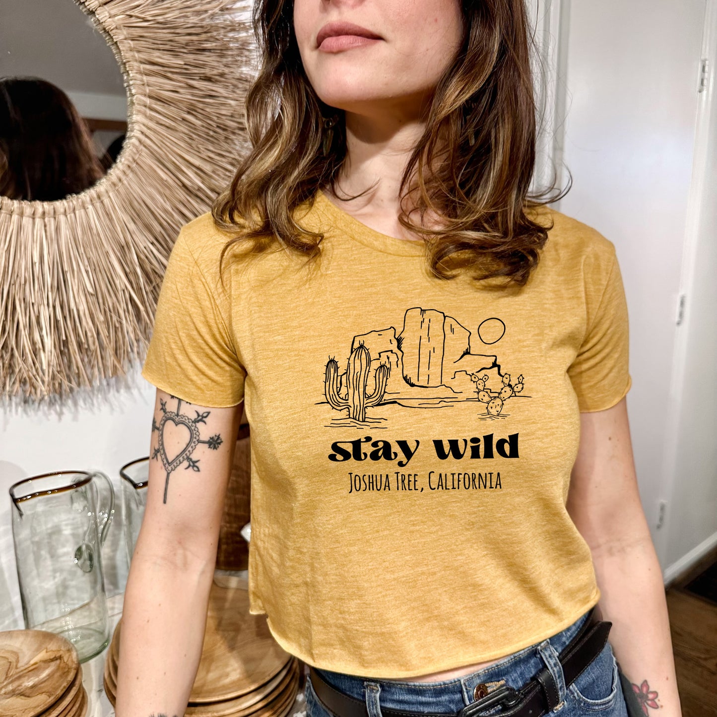 a woman standing in front of a mirror wearing a yellow shirt