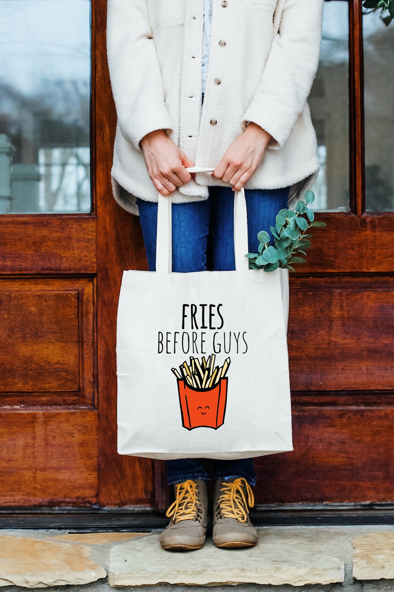 a woman holding a bag that says fries before guys