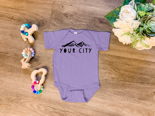a baby bodysuit sitting on top of a wooden floor