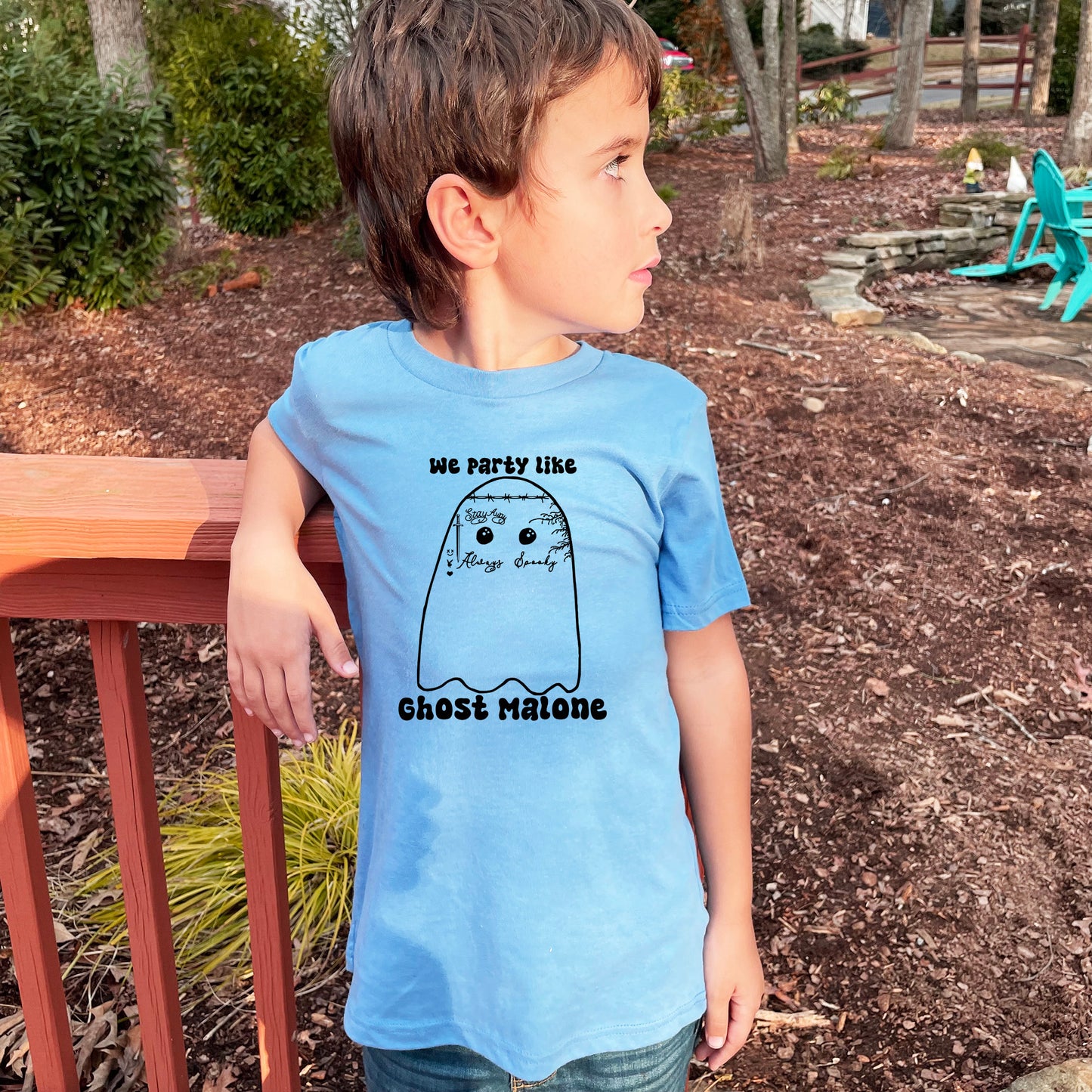 a young boy wearing a blue shirt with a ghost on it