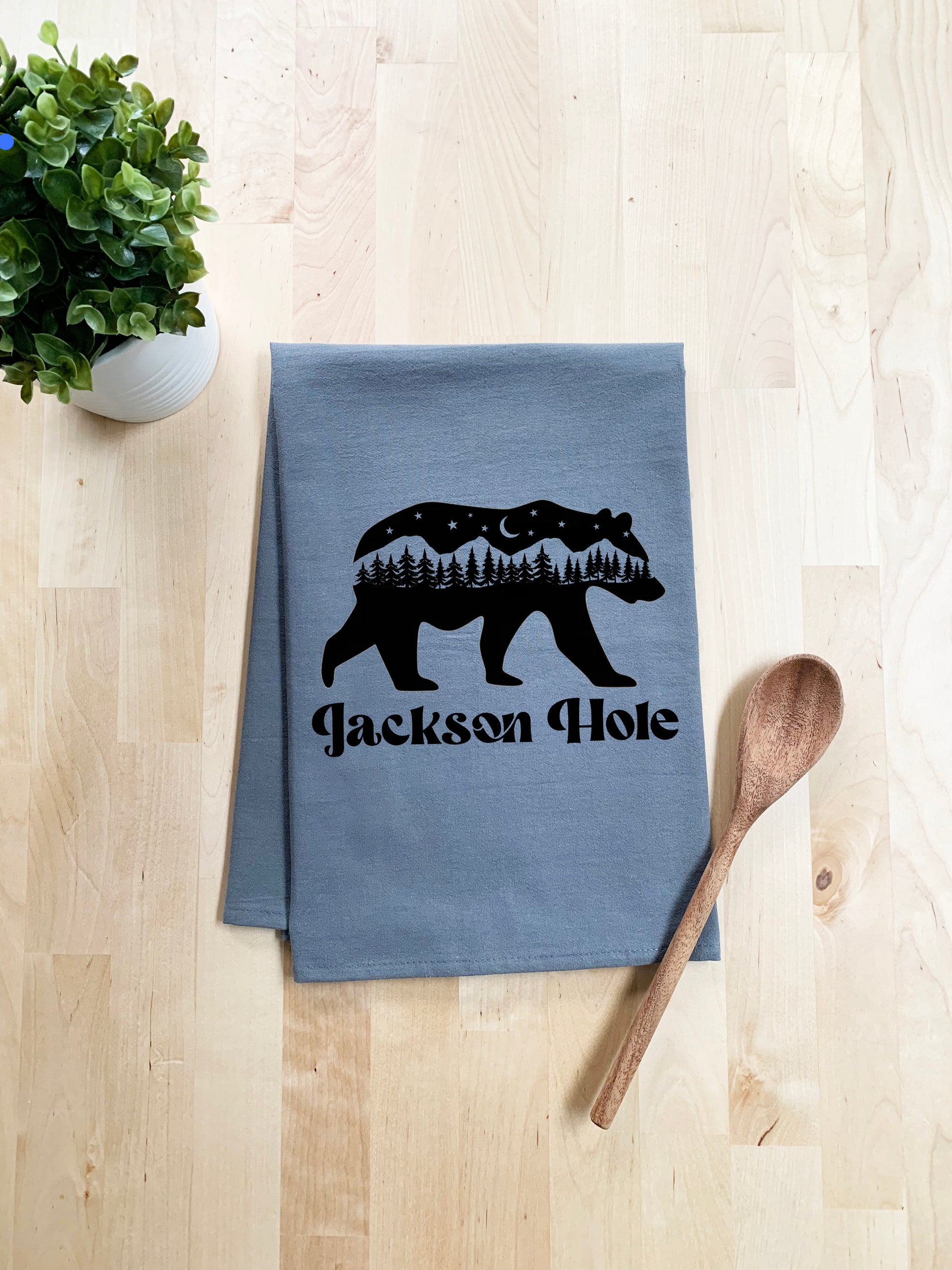 a tea towel with a bear and trees on it
