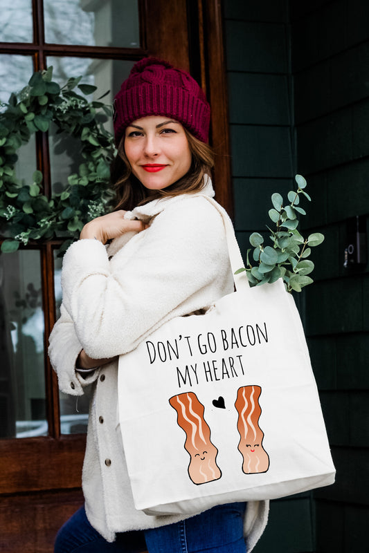 a woman holding a bag that says don't go bacon my heart