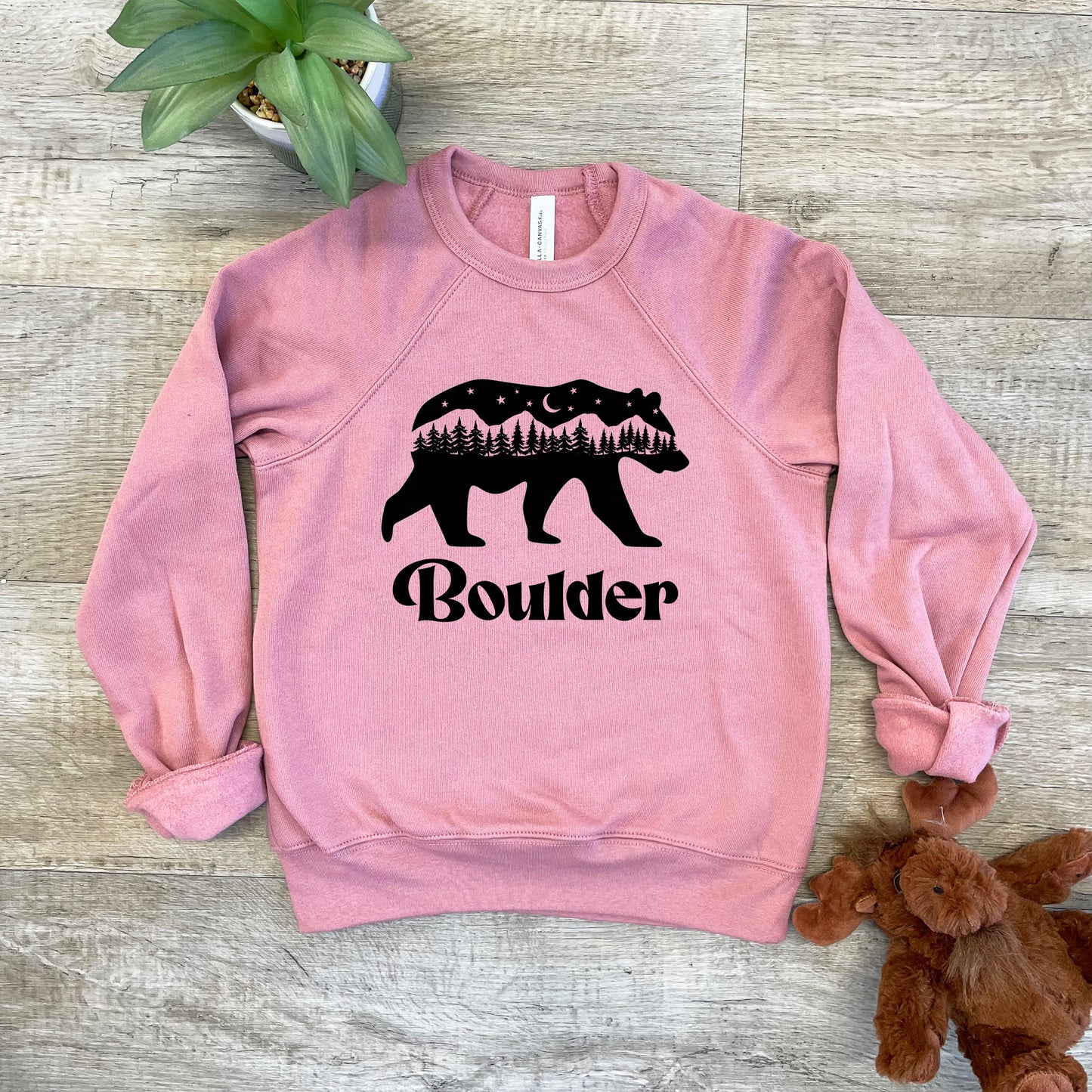 a pink sweatshirt with a bear and trees on it