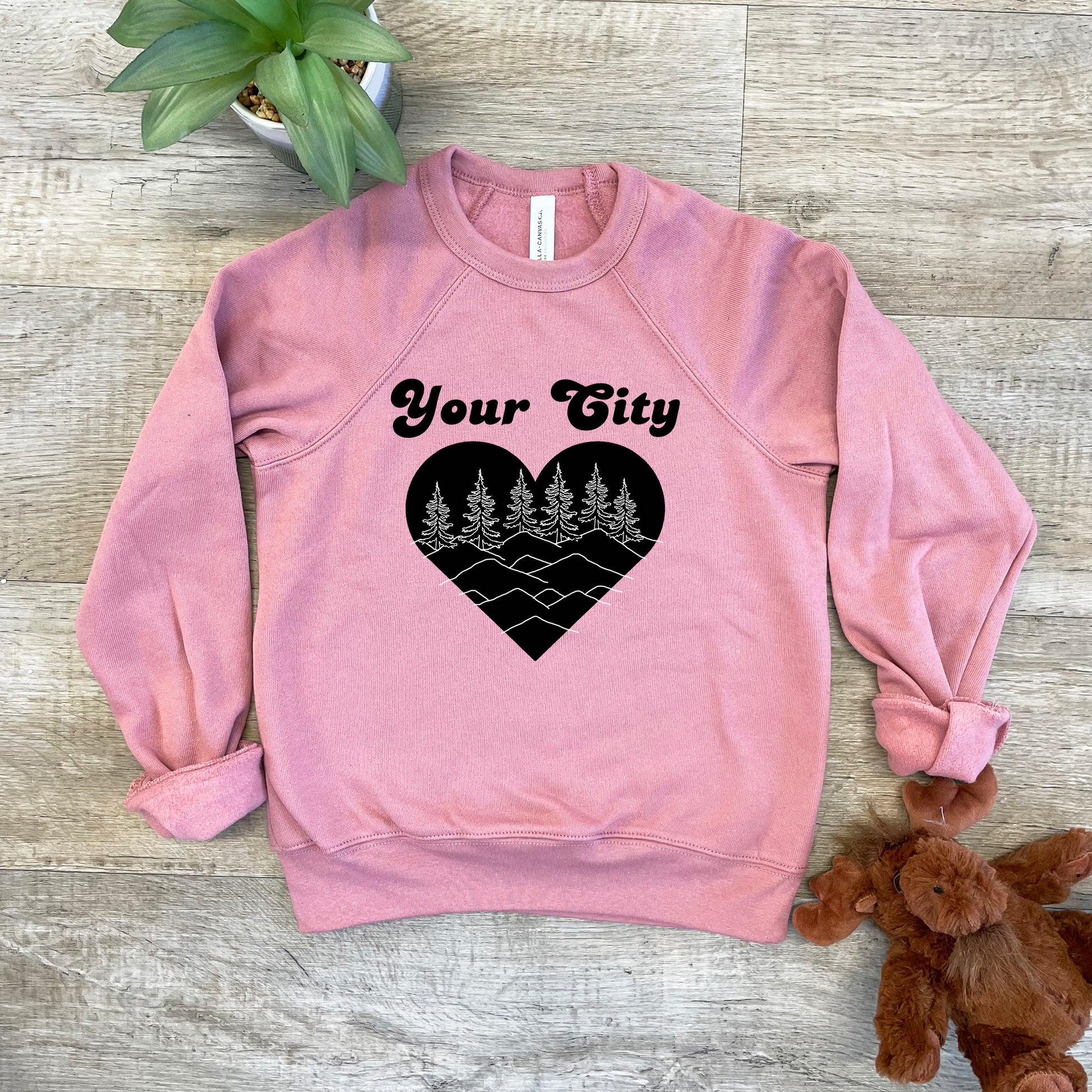 a pink sweatshirt with a heart and trees on it