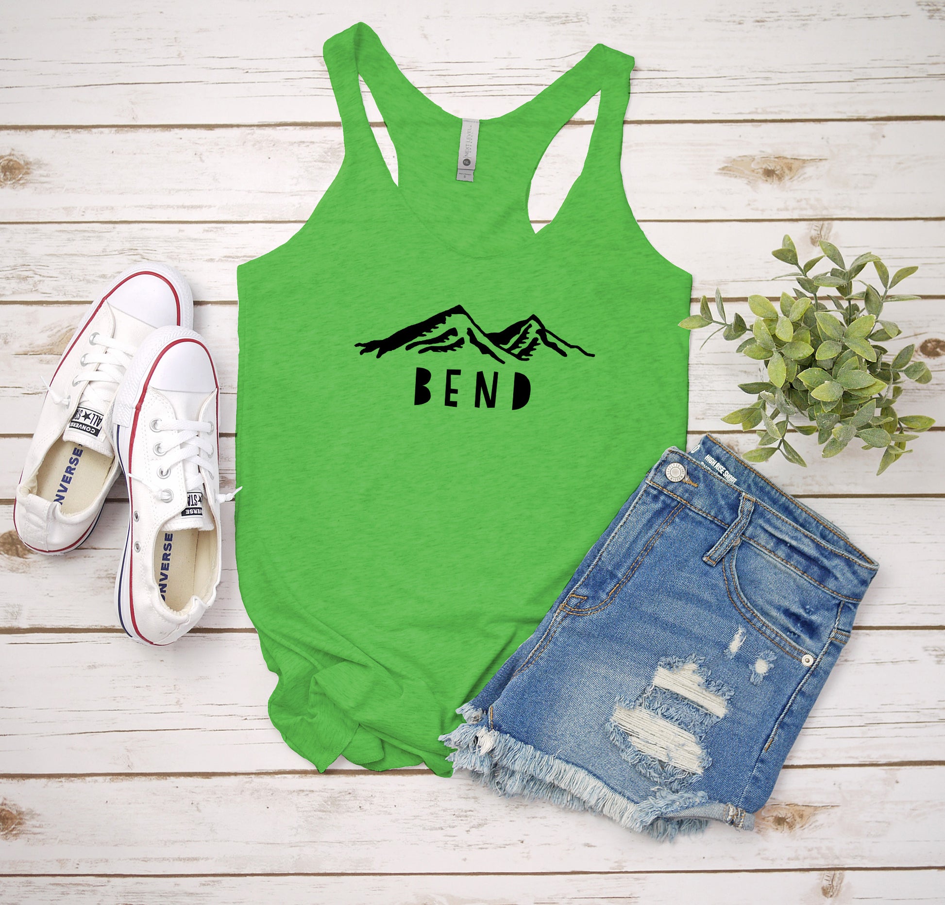 a green tank top with the word end on it next to a pair of shorts