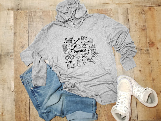 a gray hoodie with a cat on it next to a pair of jeans